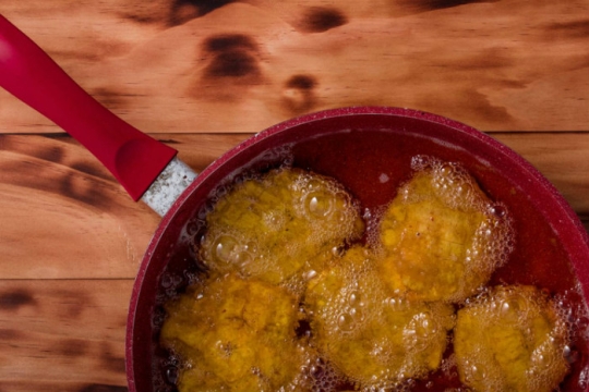 Fritters frying in a red pan